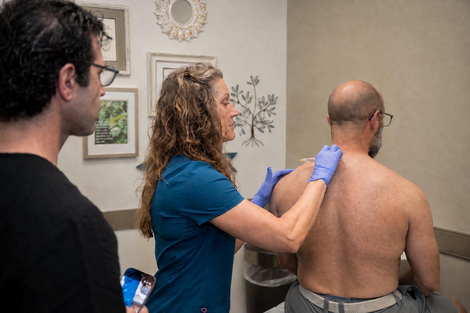Dr. Ferree demonstrating injection technique on a patient, observed by a provider